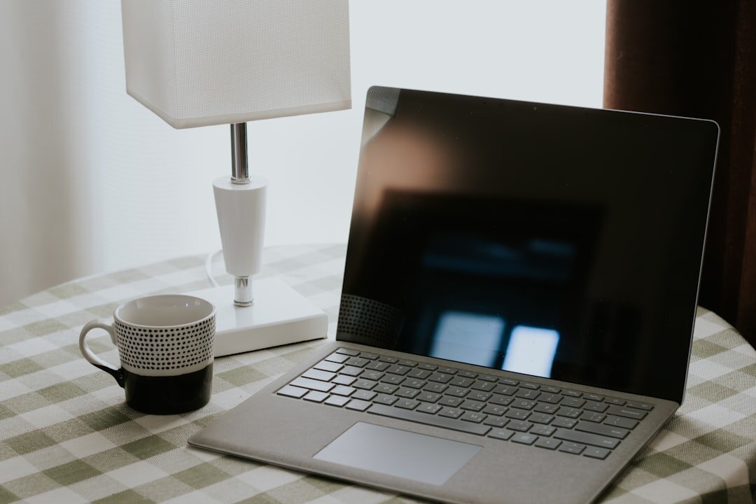 Digital media content creation setup with laptop and microphone on clean desk